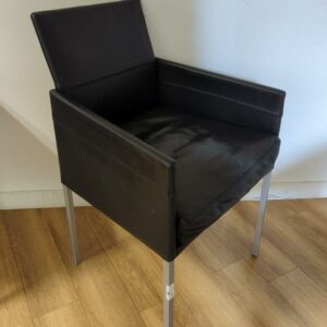Fauteuil design Karl Friedrich Foster modèle Texas édition KFF recouvert de cuir noir, piètement en acier à section carrée, assise amovible. Dim : 86 x 53 x 53 cm.