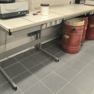 Paillasse de laboratoire, plateau en carrelage blanc, piètement en métal gris avec prises électriques intégrées. Dim : 90 x 274 x 77 cm. (labo)