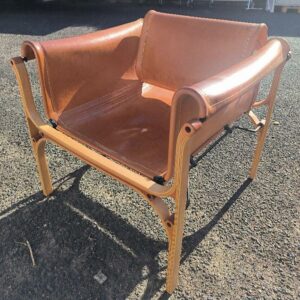 Fauteuil design Cristián Valdés modèle H édition Cristián Valdés SpA, structure et piétement en bois, recouvert de cuir brun cognac. Dim : 67 x 70 x 67 cm. Localisation: 30 rue Beauregard - 60440 Nanteuil-le-Haudouin