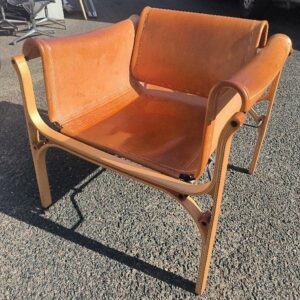 Fauteuil design Cristián Valdés modèle H édition Cristián Valdés SpA, structure et piétement en bois, recouvert de cuir brun cognac. Dim : 67 x 70 x 67 cm. (légères griffures sur le dossier). Localisation: 30 rue Beauregard - 60440 Nanteuil-le-Haudouin