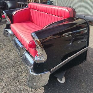 Canapé automobile de style rétro, réalisé à partir d’un élément de carrosserie automobile, avec sellerie capitonnée en simili cuir rouge, carrosserie noire, pare-chocs et éléments chromés. Dim : 80 x 180 x 76 cm. Localisation : 30 rue Beauregard 60440 Nanteuil-le-Haudouin.