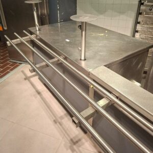 Comptoir en inox comprenant un placard à 2 portes coulissantes et une rampe avec rail à plateaux. Dimension meuble : 126 x 130 x 87 cm. Longueur totale : 330 CM