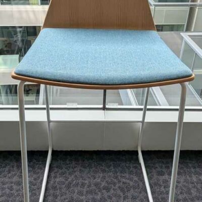 Paire de chaises hautes de marque COALESSE, coque en bois, galette d’assise en tissu bleu, piètement en acier laqué blanc. 91 x 46 x 52 cm. Localisation : 1 ouest