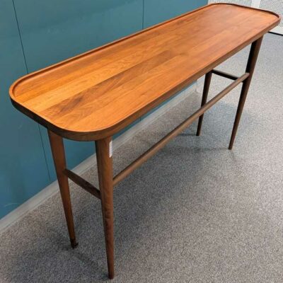 Console à plateau rectangulaire à bords arrondis en bois reposant sur 4 pieds droits avec entretoise déportée. 80 x 125 x 35 cm. Localisation : 2 est
