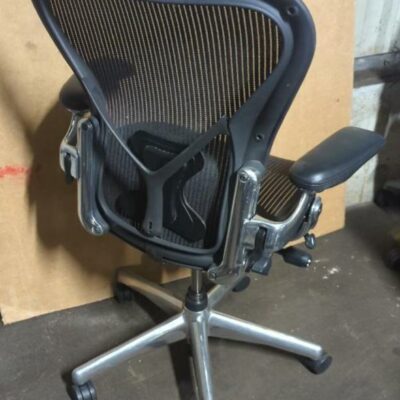 Fauteuil pivotant ajustable sur roulettes de marque Herman Miller modèle Aeron noir (2 picots arrière). 110 x 70 x 65 cm. Localisation : 8 rue de la Fossé aux Leux 91700 Ste Geneviève des Bois